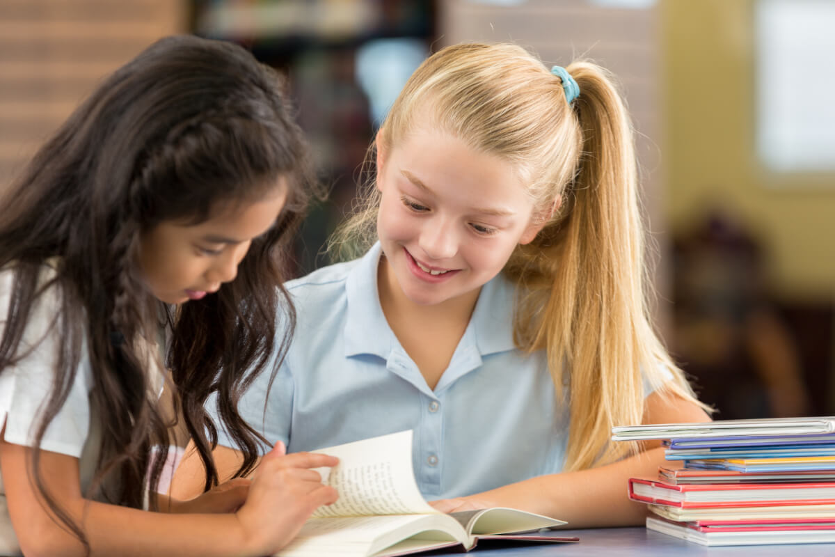 Two Wise Owl students reading together at a table